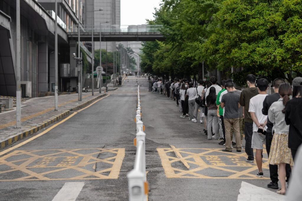 A large group of people lined up along a city street, highlighting urban planning and human patience.